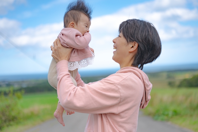 赤ちゃんを高く抱っこする女性